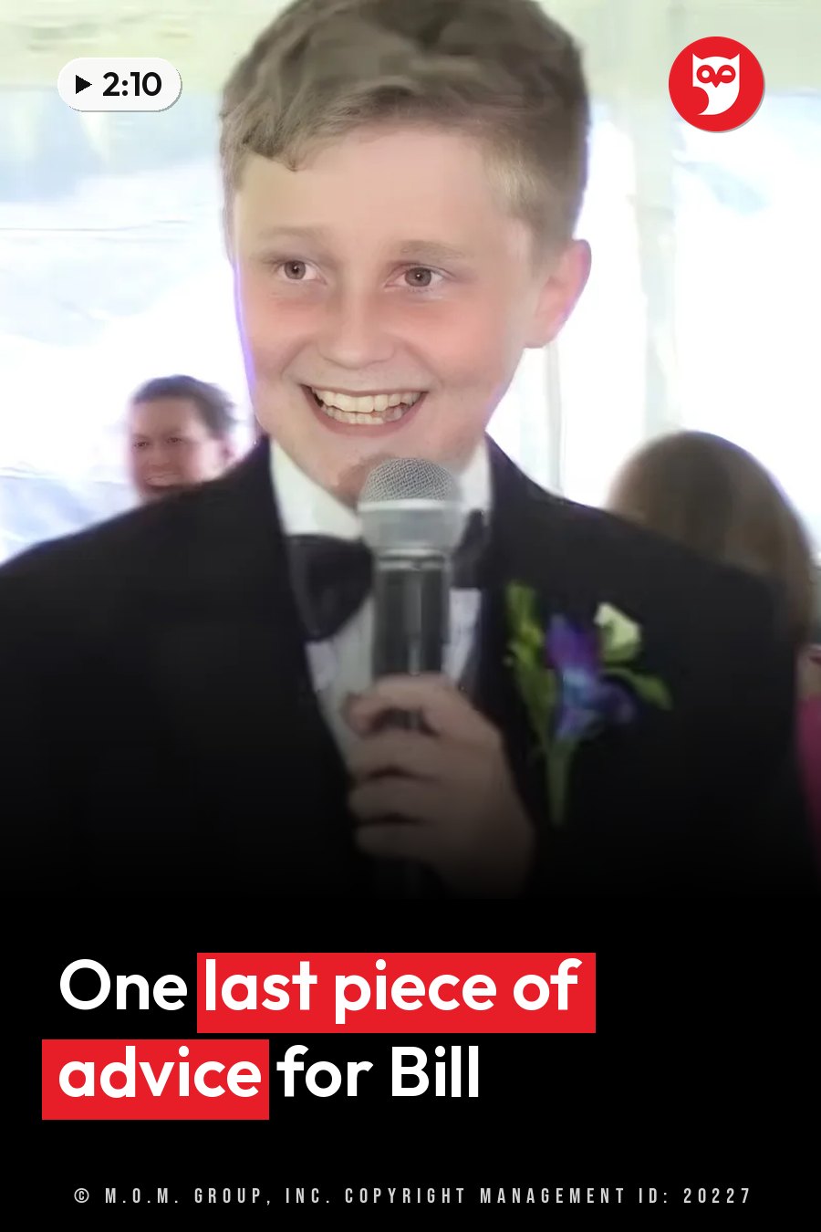 A young boy in a suit smiles as he holds a microphone, with people behind him. A headline runs in white letters across the lower third.