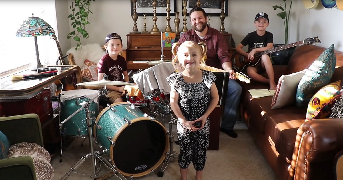 A cozy living room with a mix of vintage and modern decor elements, with children playing musical instruments and adults smiling.