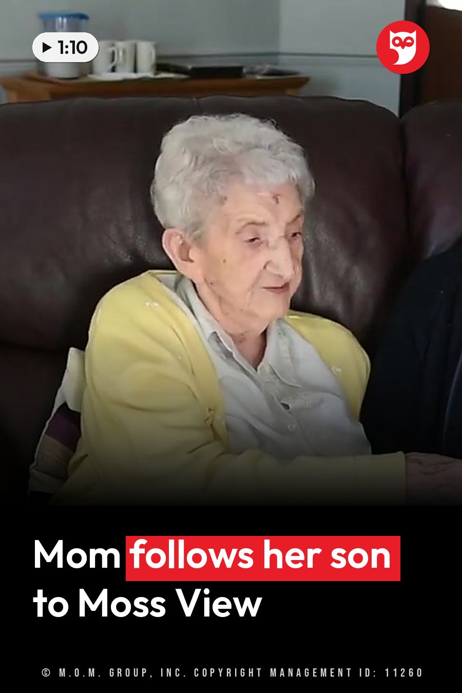 An elderly woman with white hair sits on a brown couch in a yellow cardigan over a light shirt. A headline runs in white letters across the lower third.