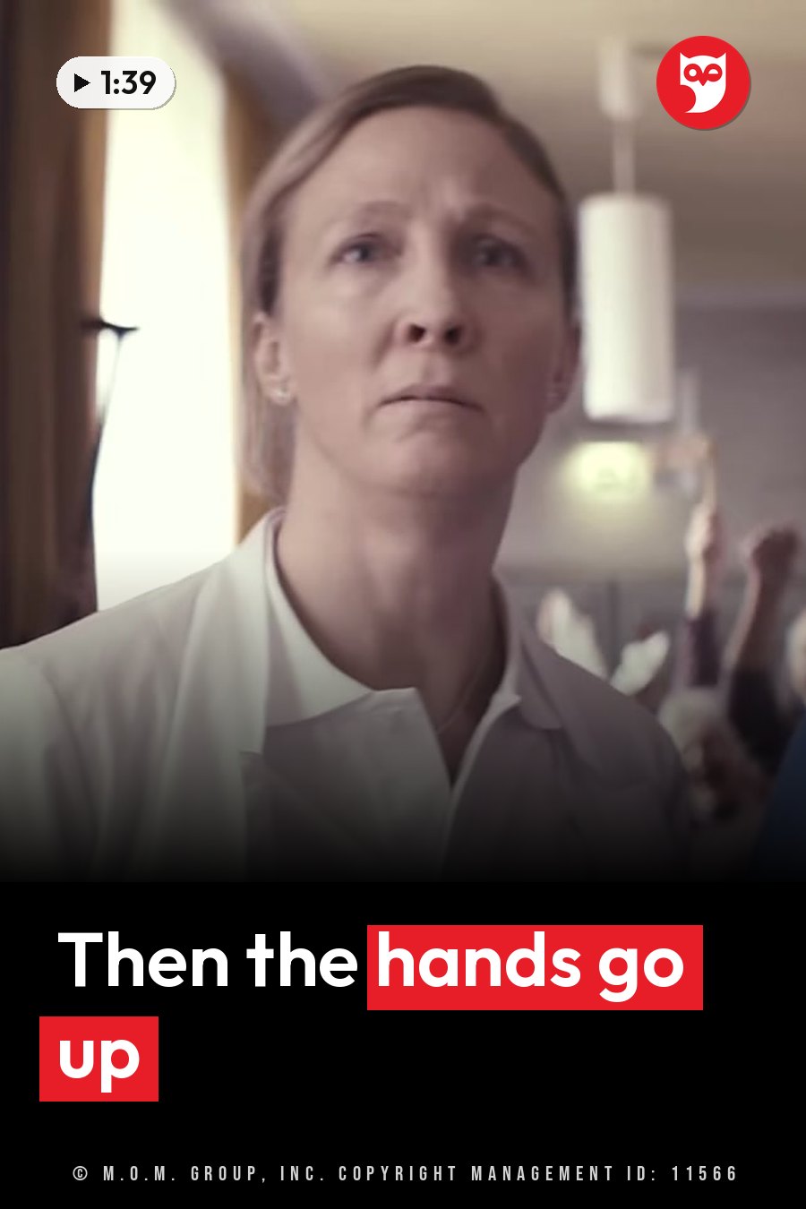 A woman in a white coat looks upward with a serious expression while blurred figures behind her raise their hands. A headline runs in white letters across the lower third.