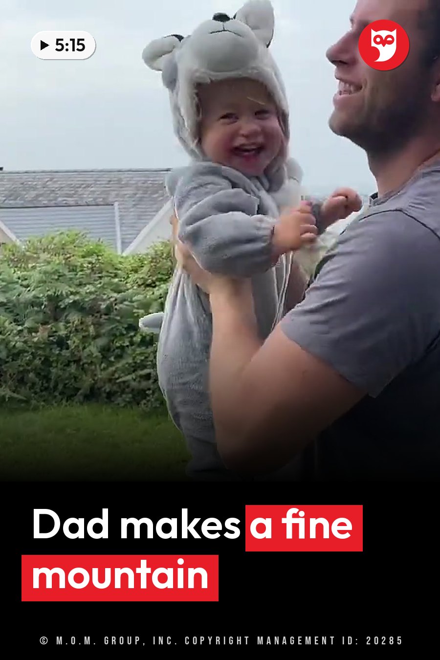 A man holds a laughing child in a gray animal costume on the grass near some bushes. A headline runs in white letters across the lower third.