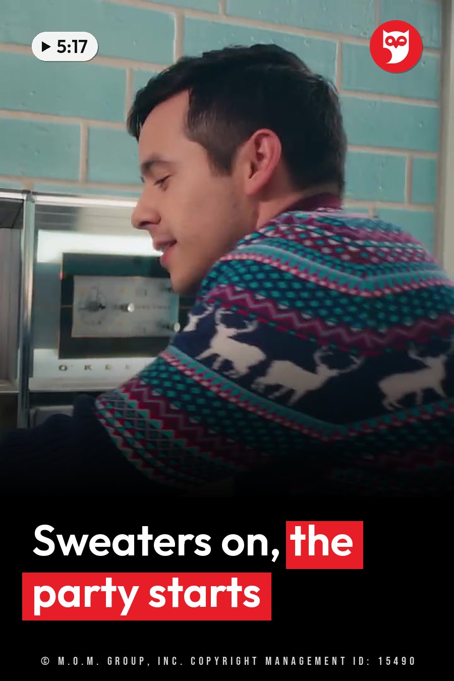 A man in a patterned sweater smiles while sitting near a brick wall with an appliance behind him. A headline runs in white letters across the lower third.