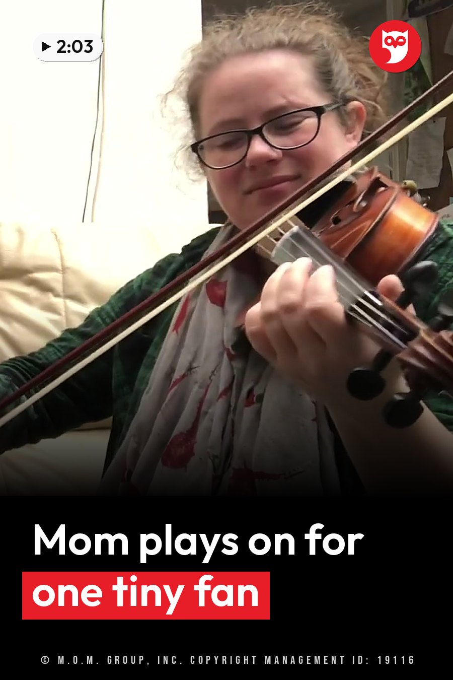 Anna Dowling, wearing glasses, plays violin while seated on a couch indoors. A headline runs in white letters across the lower third.