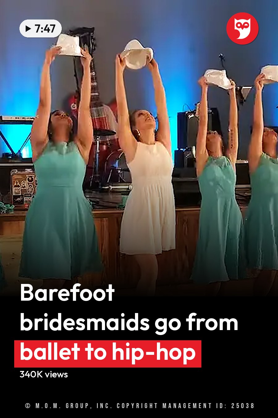A dance group of young adult females performing on a wooden floor with blue stage lighting, likely an indoor hall or studio at night. The headline runs in white letters across the lower third.