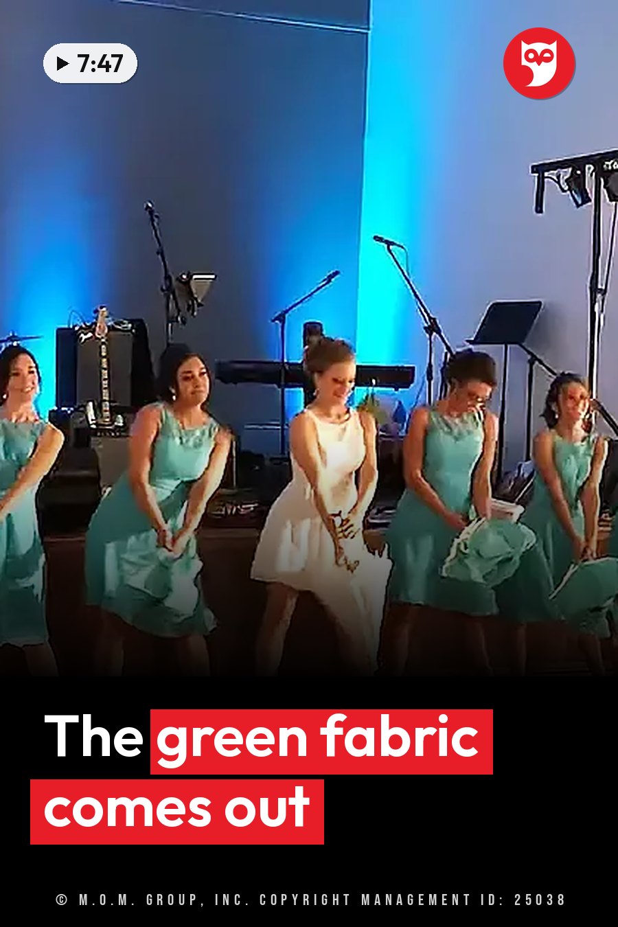 Five women in dresses stand on a stage holding green fabric, with microphones and music equipment nearby. A headline runs in white letters across the lower third.