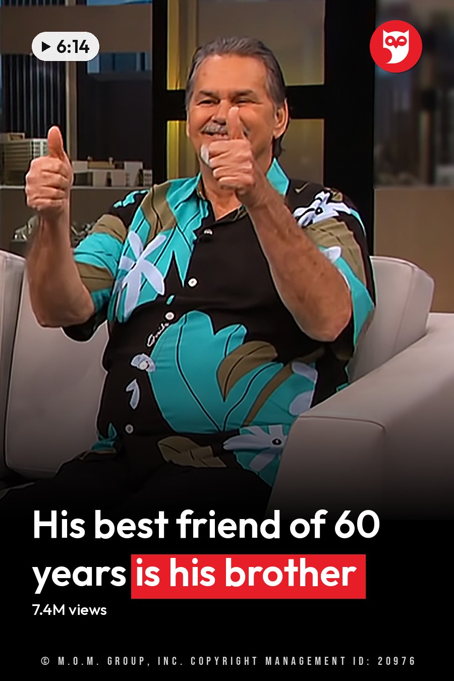 Two older adult males seated on a white couch in a modern studio with dark panels and soft lighting, wearing patterned shirts and beige pants. The headline runs in white letters across the lower third.