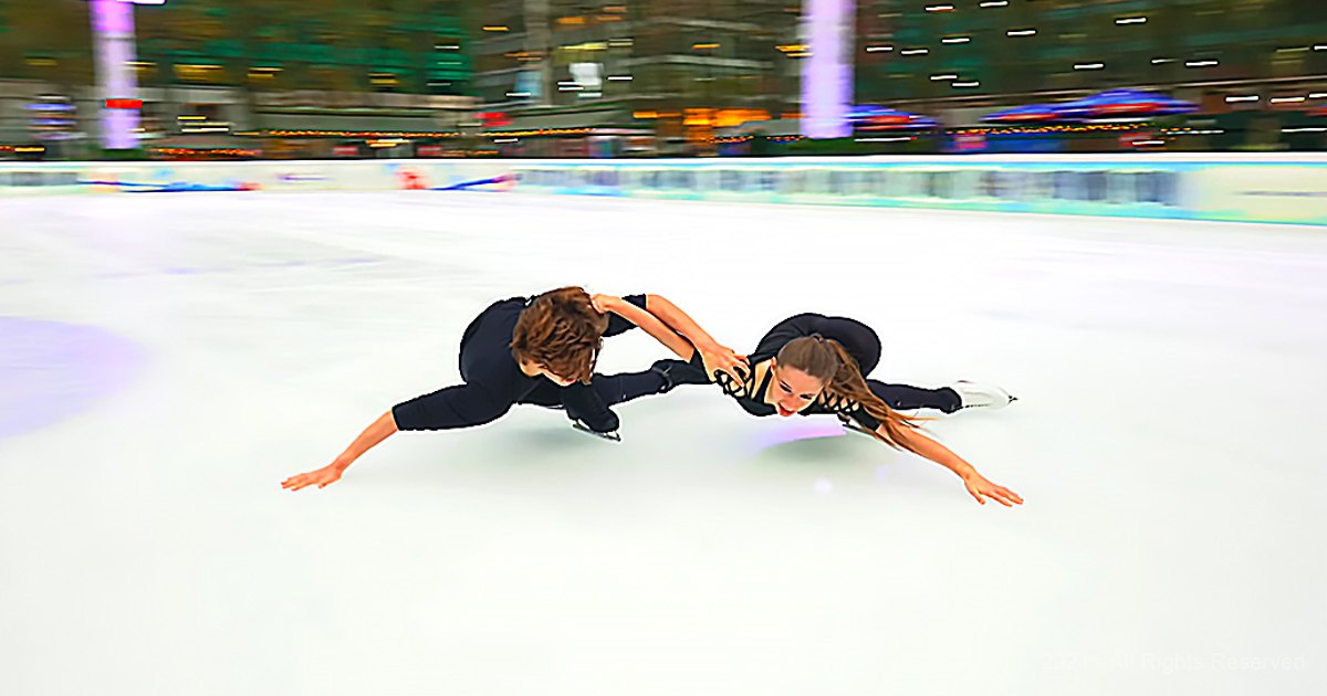 Young adult male and female figure skaters in a well-lit indoor ice rink with smooth skating surface, wearing fitted black attire and white skate boots.