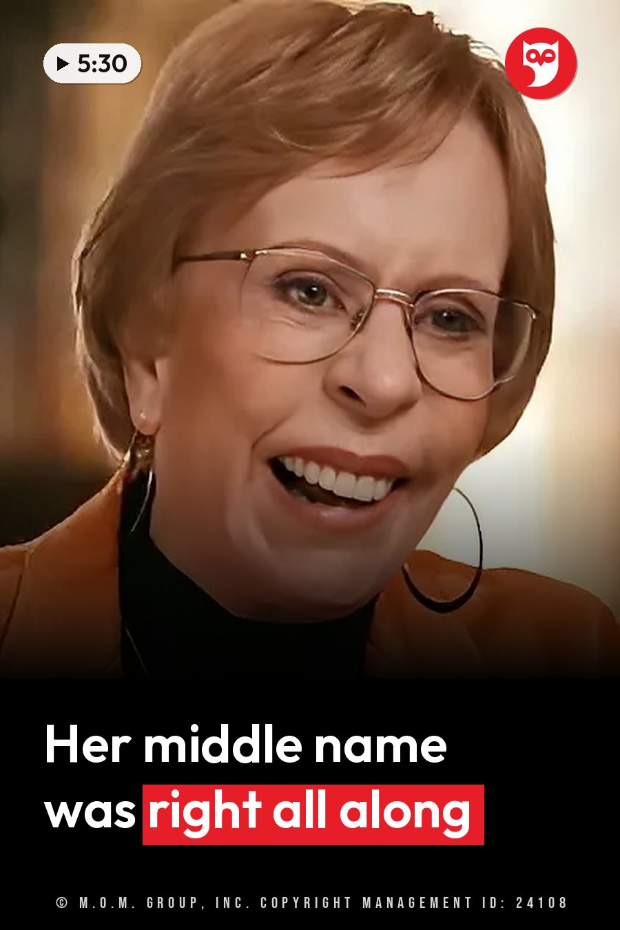 Carol Burnett, in glasses, hoop earrings and an orange jacket over a black top, smiles broadly. A headline runs in white letters across the lower third.