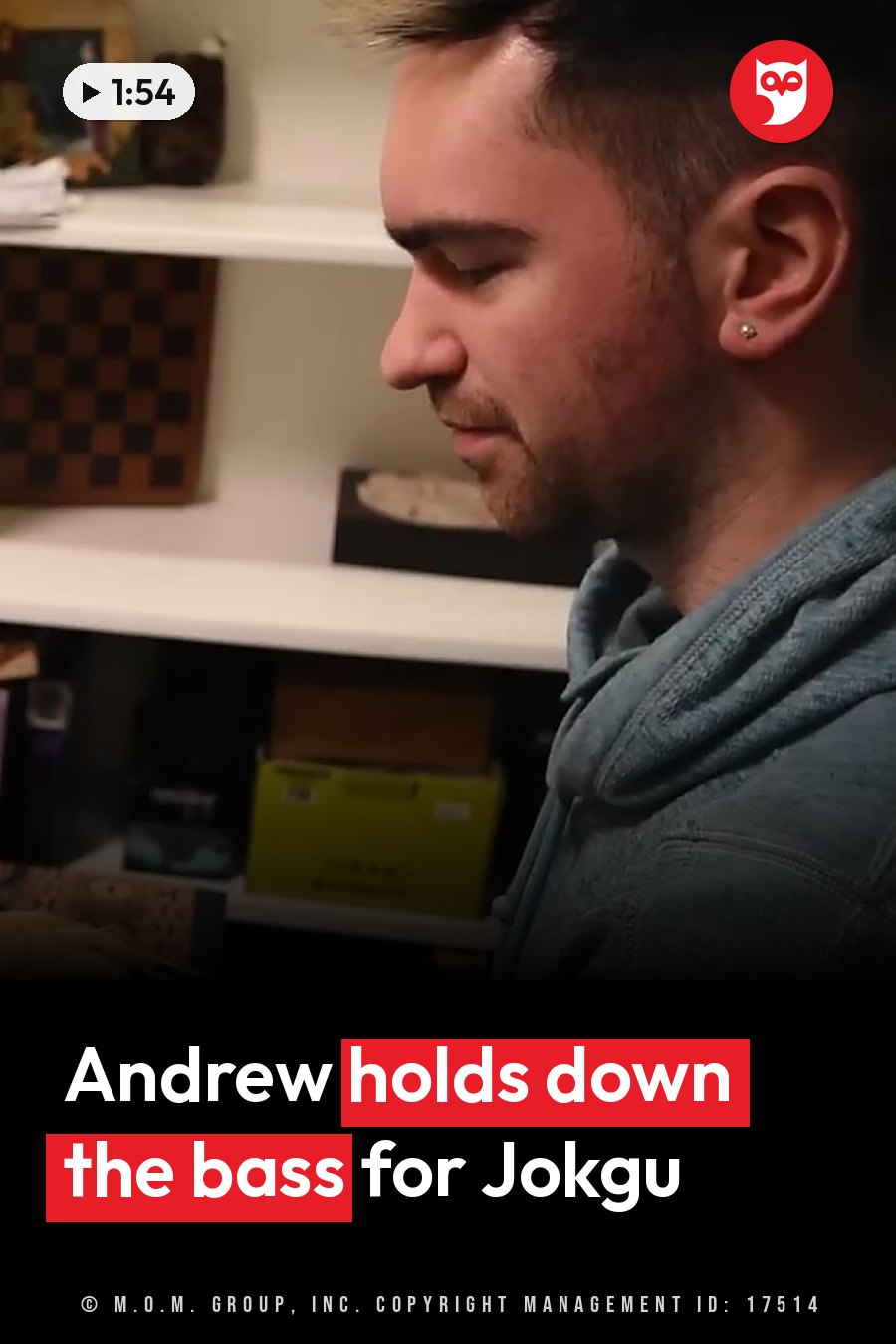 A man with short hair and an earring, wearing a hoodie, looks down in front of shelves with items on them. A headline runs in white letters across the lower third.