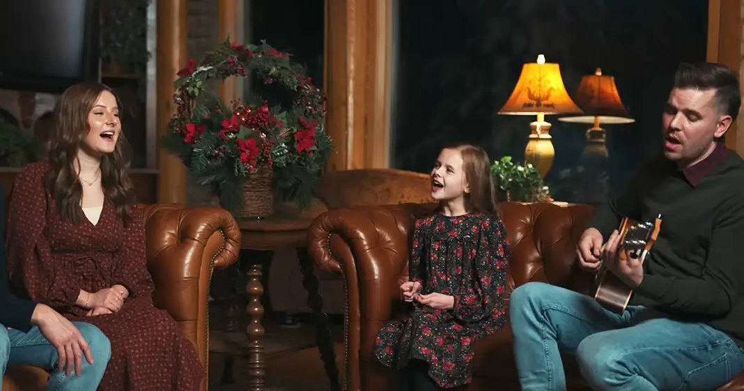 A cozy indoor living room scene with a family with adults in spring or summer attire, rustic furniture, and warm lighting.