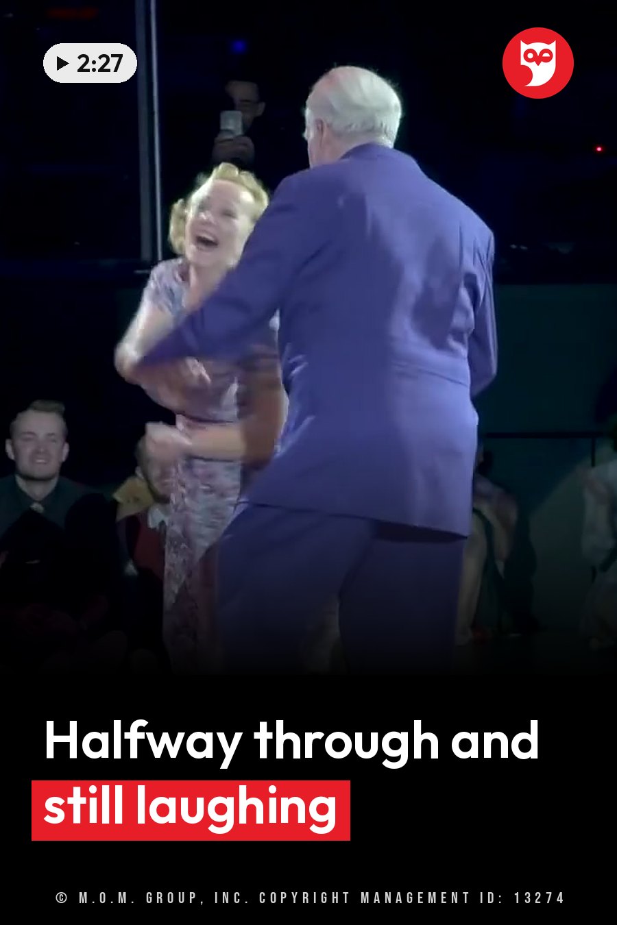 An older couple dances on a stage. The woman is laughing, and the man, in a blue suit, faces away from the camera. A headline runs in white letters across the lower third.