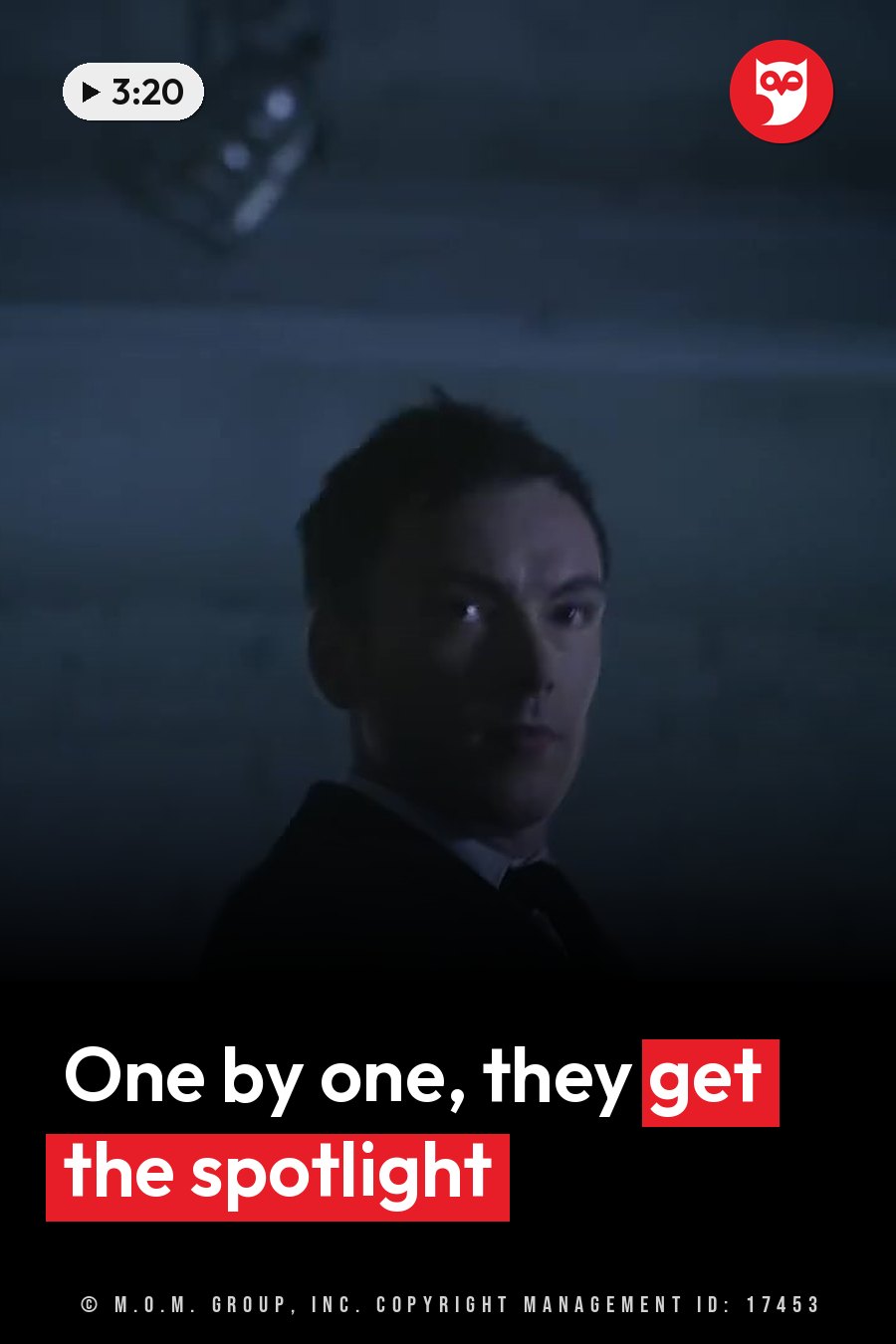 A man in a suit looks straight ahead with a serious face under dim blue light. A headline runs in white letters across the lower third.