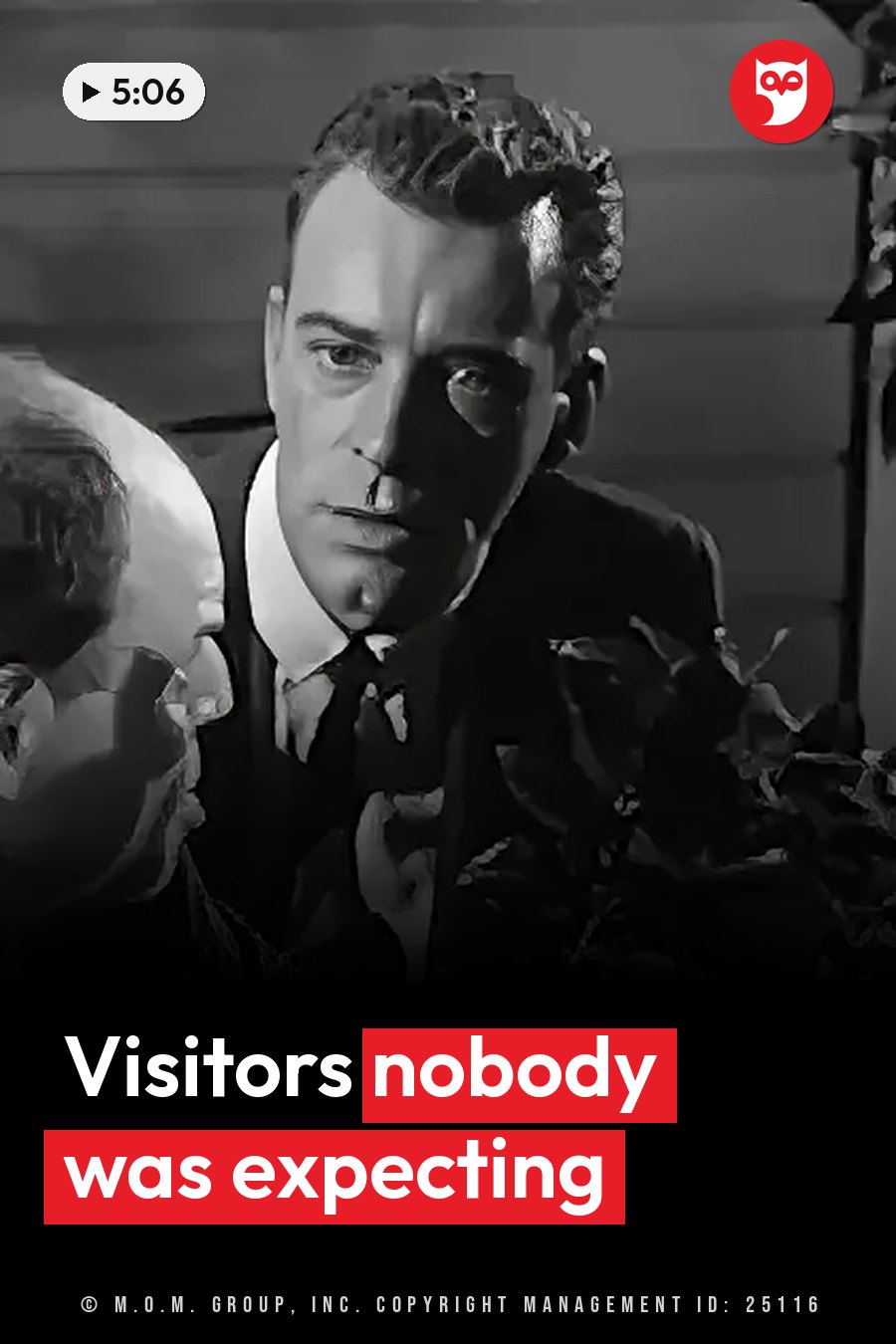 A man in a suit looks ahead with a serious face while another person leans in close beside him. A headline runs in white letters across the lower third.
