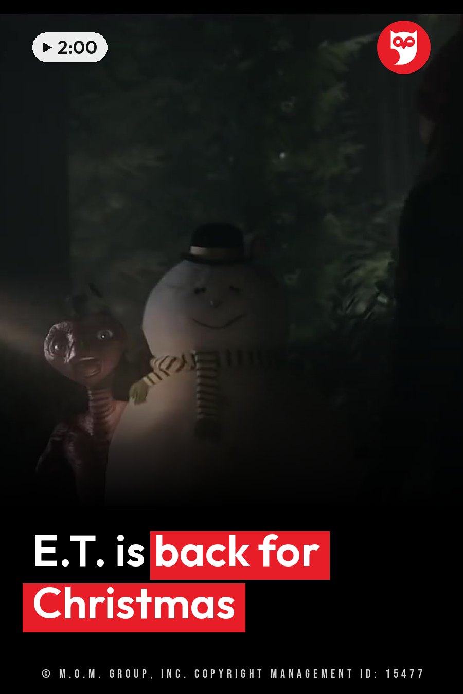 E.T., a small creature, stands beside a snowman in a hat and scarf under dim light near trees. A headline runs in white letters across the lower third.