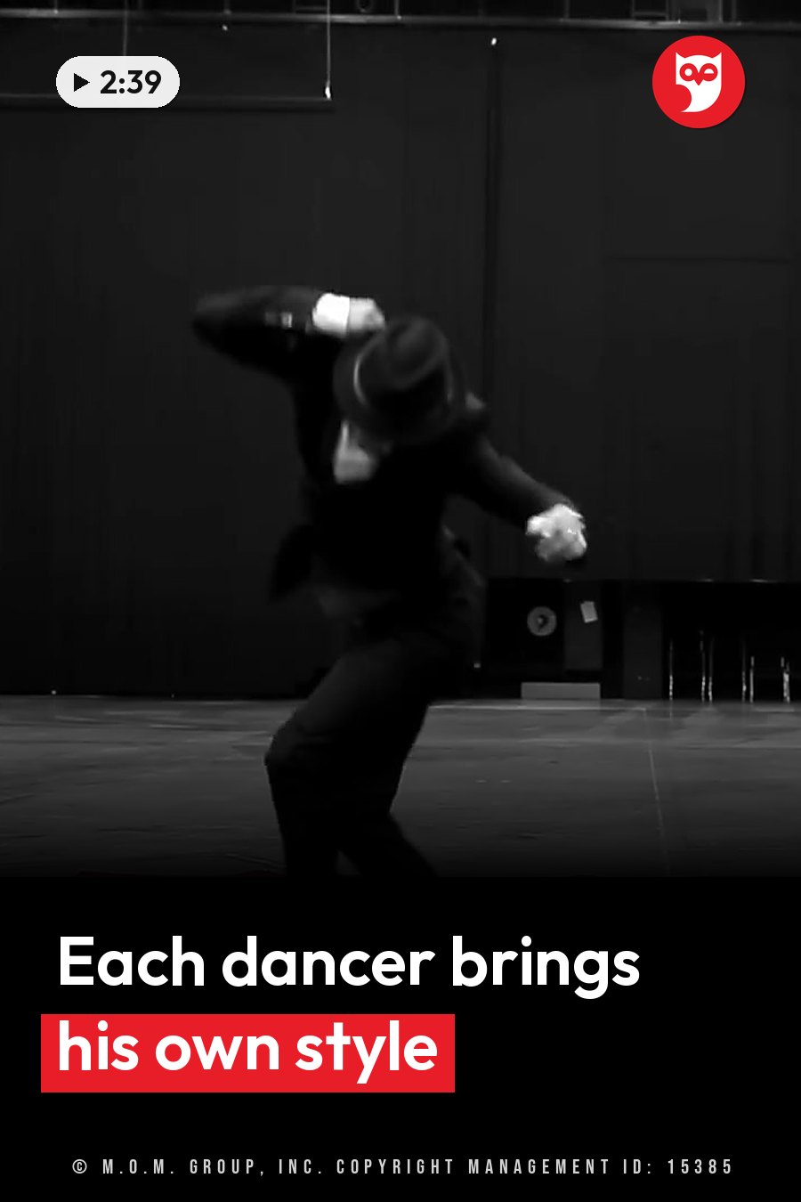 A person in dark clothing and a hat dances on a stage with arms stretched out against a plain backdrop. A headline runs in white letters across the lower third.