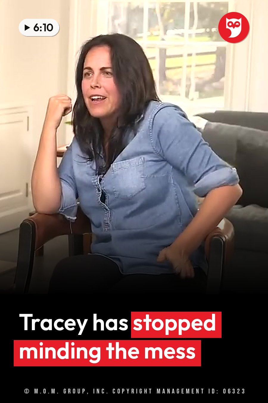 A woman in a denim shirt sits in a chair and gestures with both hands as she talks. A headline runs in white letters across the lower third.