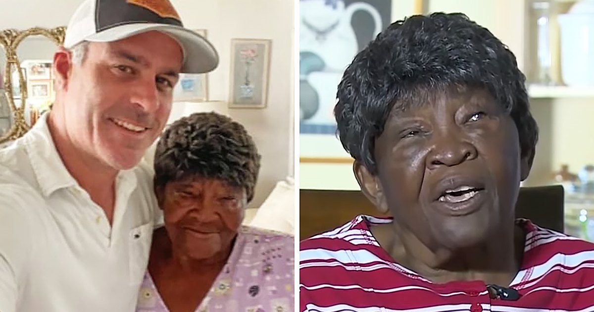An adult male singer with an older adult female companion indoors, wearing a white polo shirt and baseball cap (white and orange), patterned top with small light-colored designs. The setting appears to be a living room or similar indoor space with framed picture on the wall.
