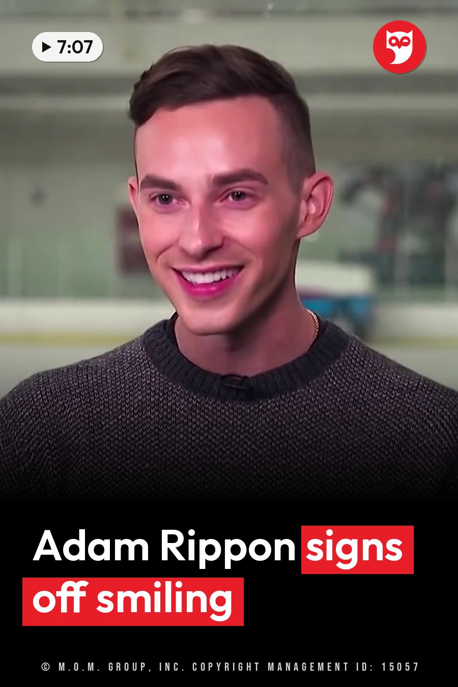 A smiling young man with short hair, wearing a gray sweater, sits indoors near glass panels. A headline runs in white letters across the lower third.