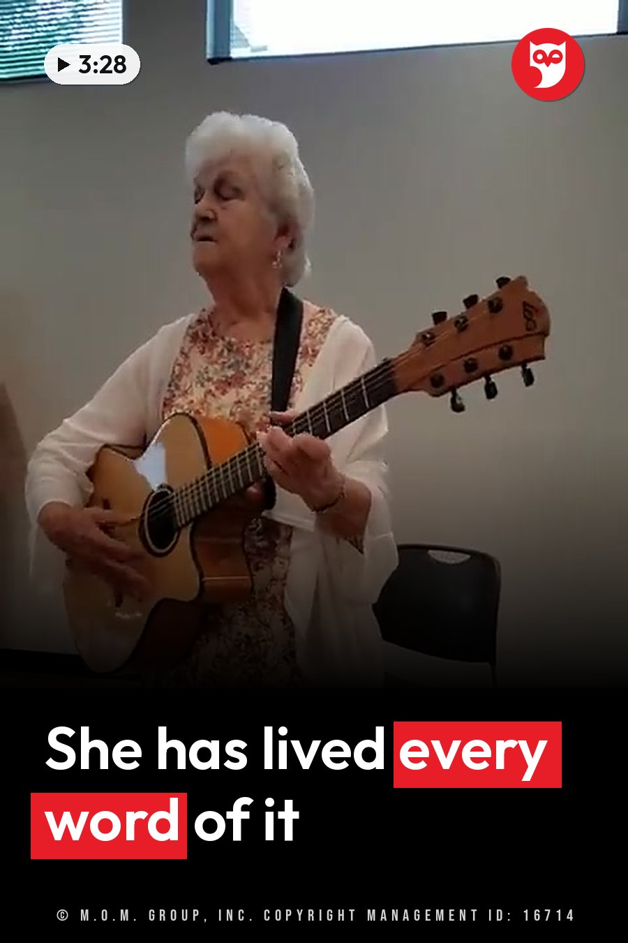 Vera plays an acoustic guitar while seated indoors near a window. A headline runs in white letters across the lower third.