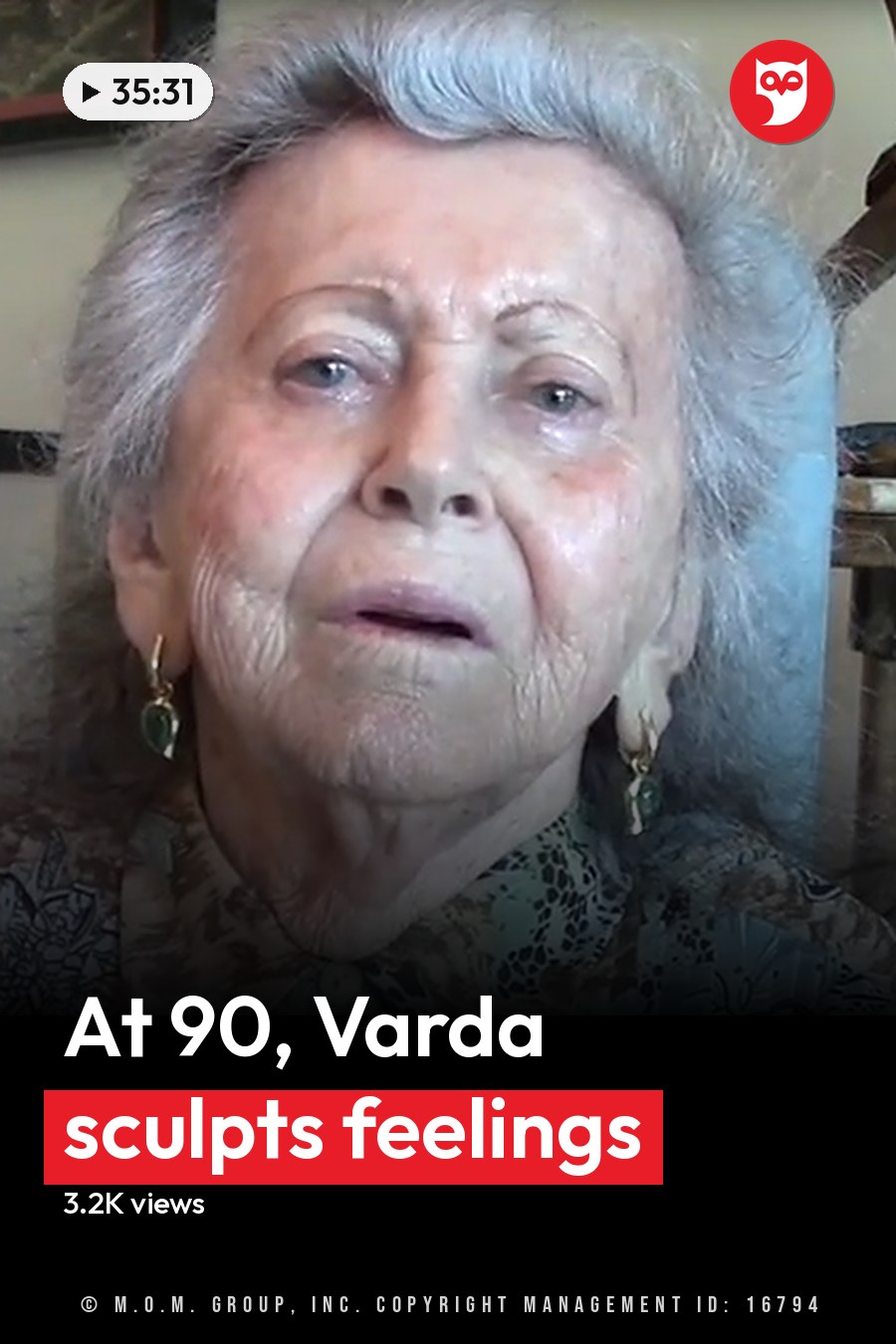 An older adult female in a home setting, wearing a patterned blouse with gold hoop earrings. A dark-colored chair and framed picture are visible in the background. The headline runs in white letters across the lower third.
