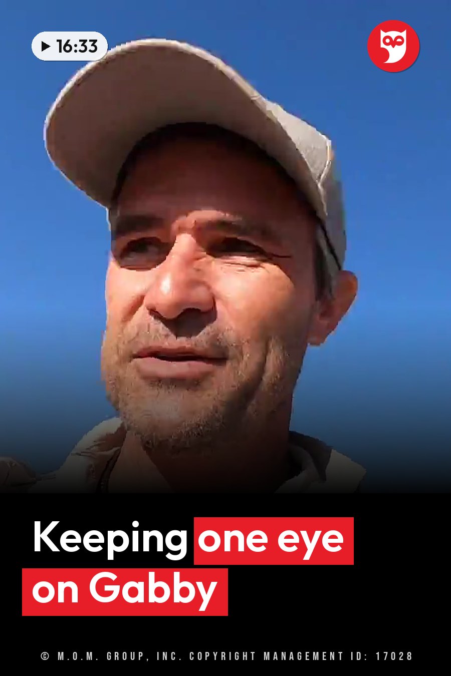 A man in a cap looks upward against a clear blue sky. A headline runs in white letters across the lower third.