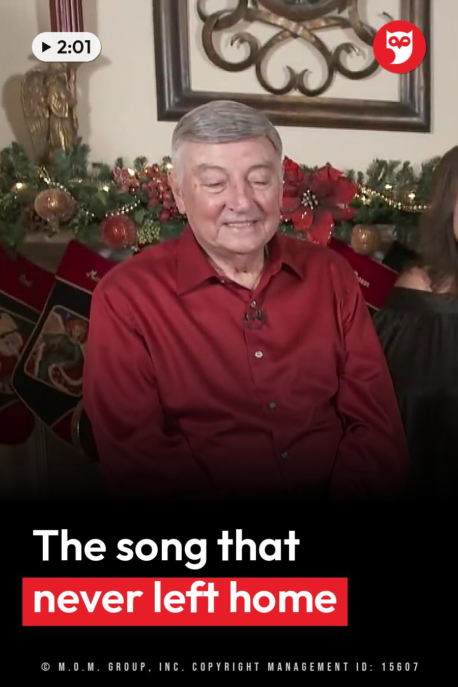 An older man in a red shirt smiles while seated near Christmas stockings and garlands. A headline runs in white letters across the lower third.