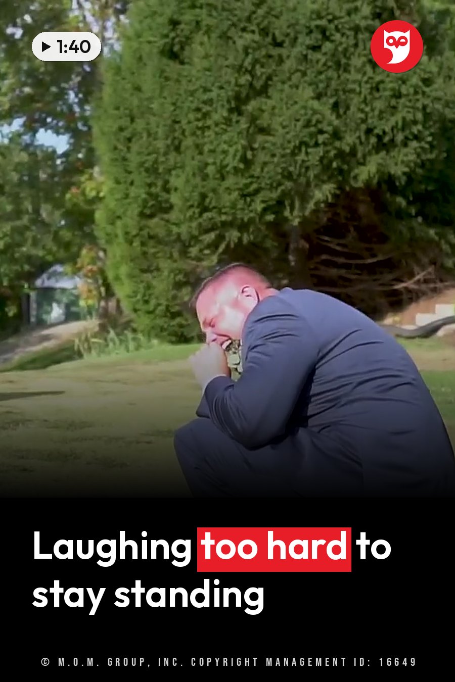 A man in a suit crouches on the grass with his hands over his face, tall green trees behind him. A headline runs in white letters across the lower third.