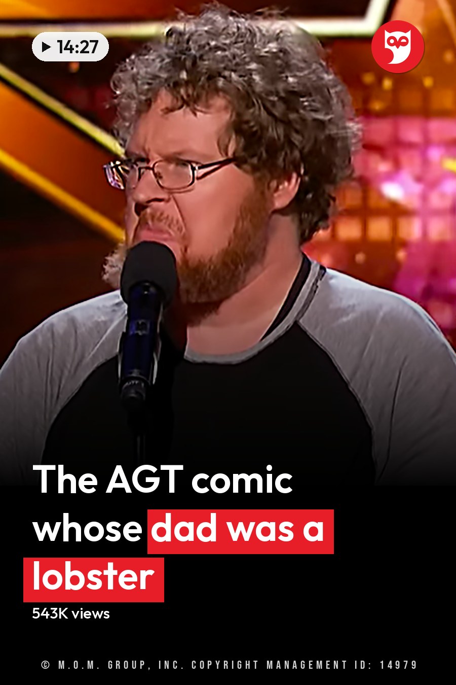 A middle-aged adult male wearing a long-sleeved raglan shirt with a relaxed fit and crew neck, performing on stage at an entertainment competition show. The headline runs in white letters across the lower third.