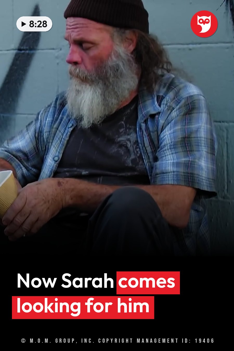 An older man with a long beard sits against a wall, holding a cup and looking down. A headline runs in white letters across the lower third.