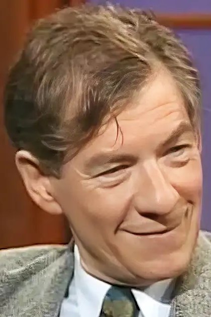 Middle-aged man in a tailored blazer with textured pattern, mid-20th century style, indoors studio setting with wooden paneling and soft lighting.