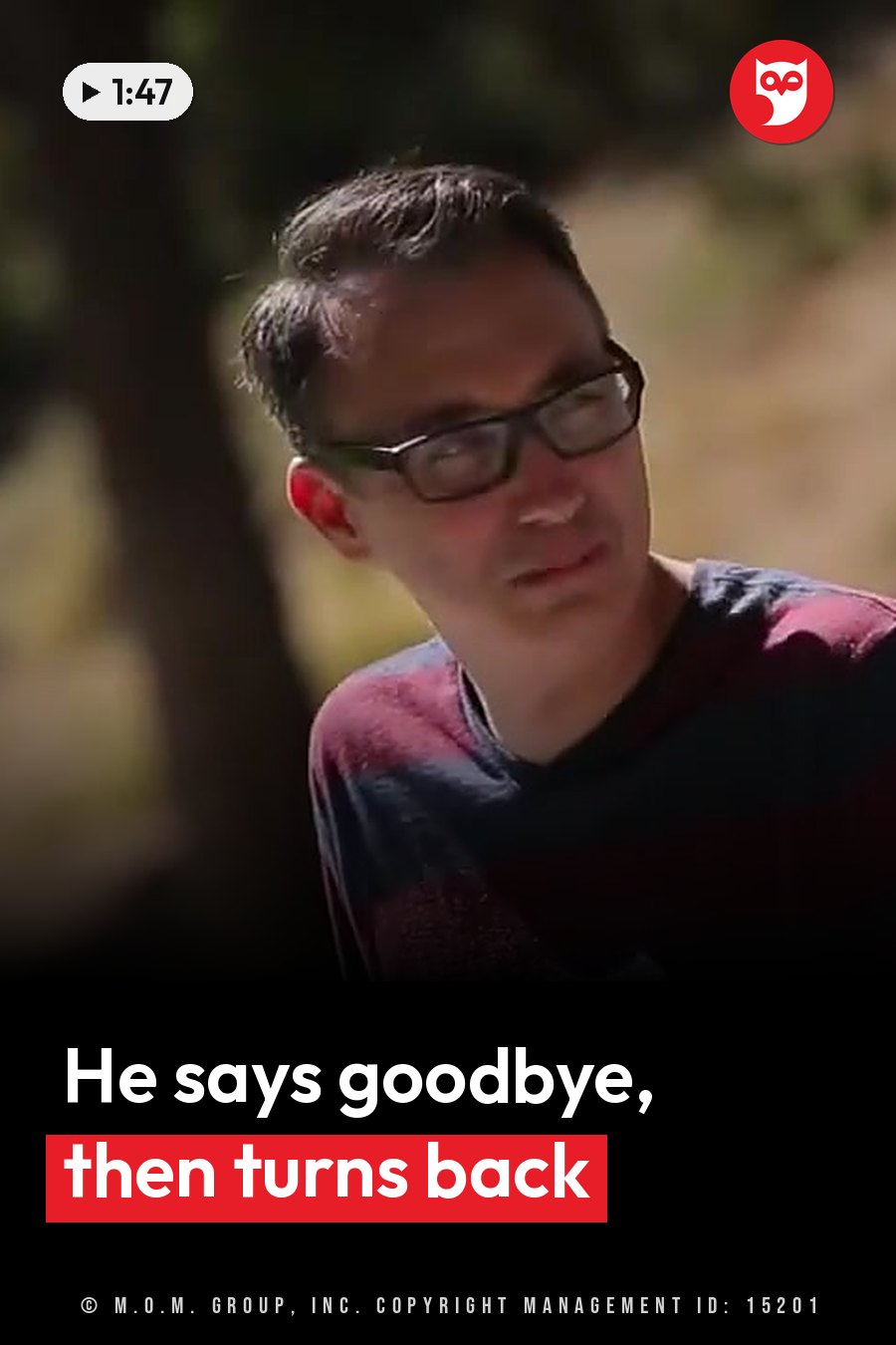 A man with glasses and a striped shirt looks down, outdoors near a tree. A headline runs in white letters across the lower third.