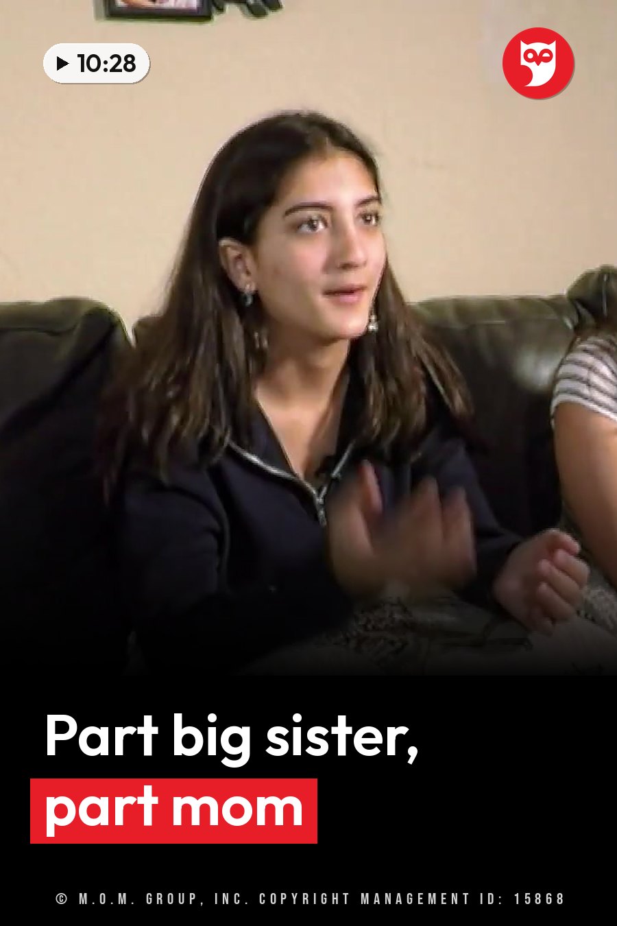 A young woman sits on a couch and gestures with her hands while talking to someone off camera. A headline runs in white letters across the lower third.