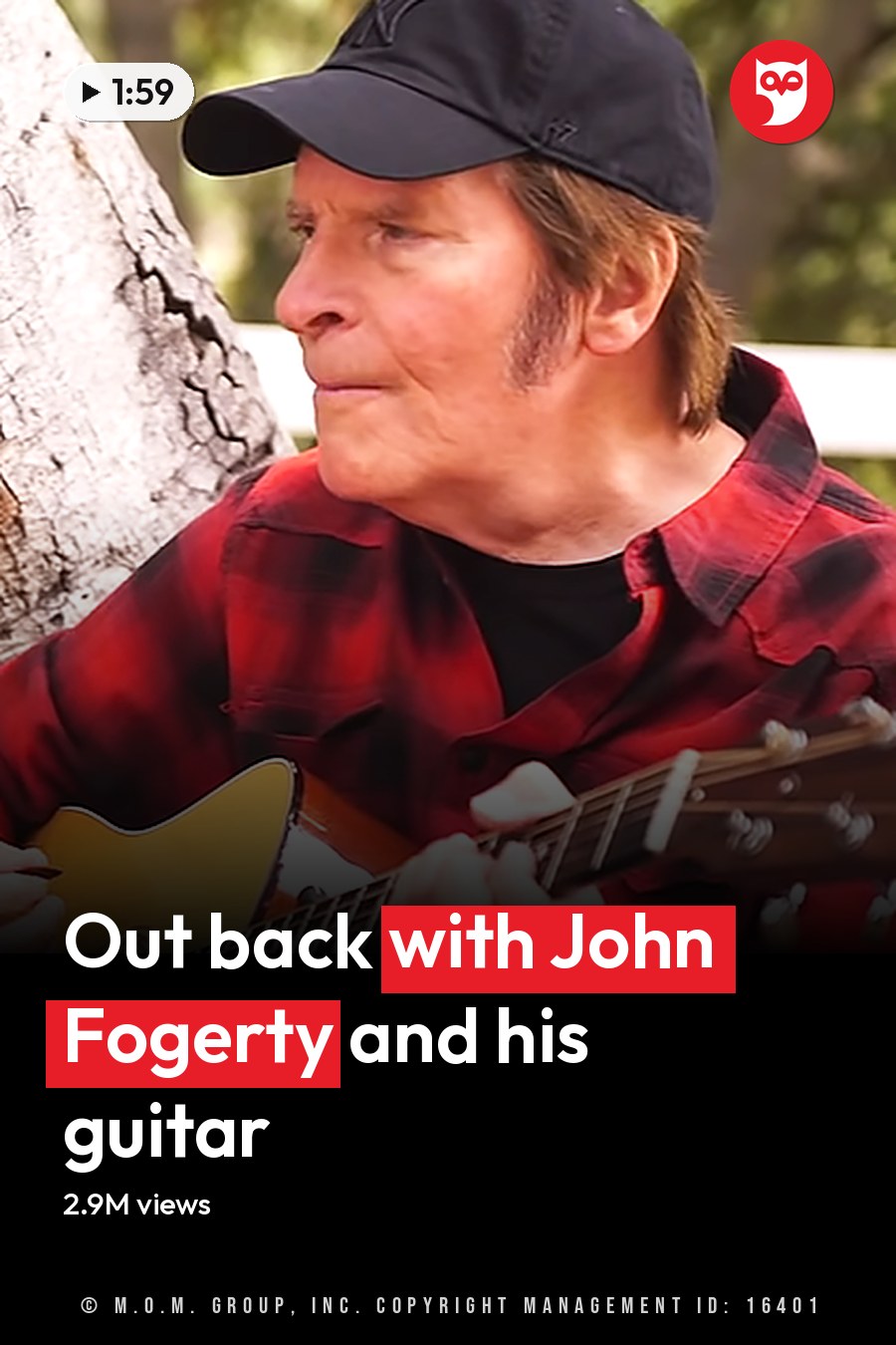Middle-aged man playing guitar outdoors amidst greenery and a white wooden fence, likely spring or summer. The headline runs in white letters across the lower third.