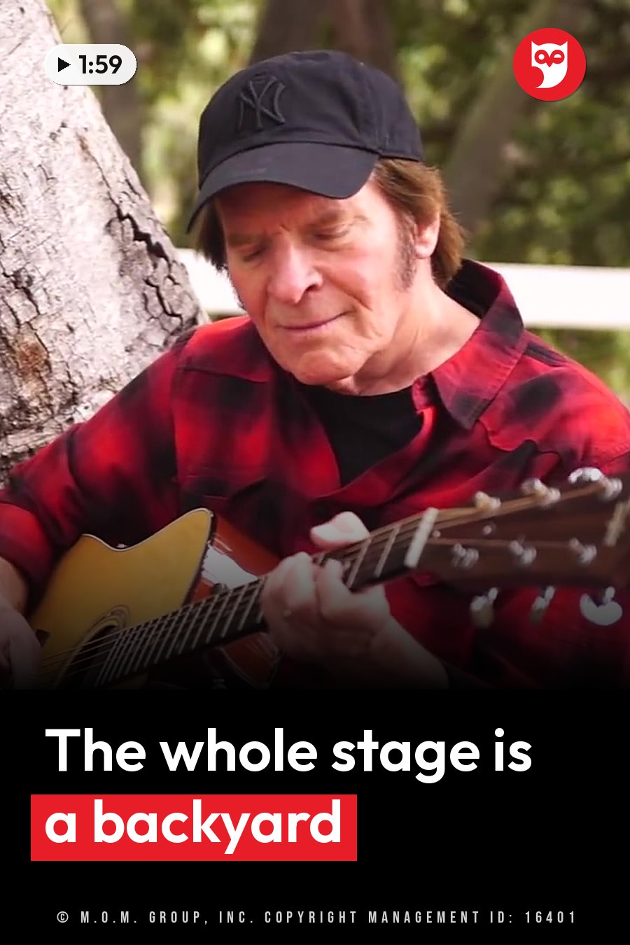 A man in a cap and red shirt plays an acoustic guitar, seated outdoors near a tree trunk. A headline runs in white letters across the lower third.