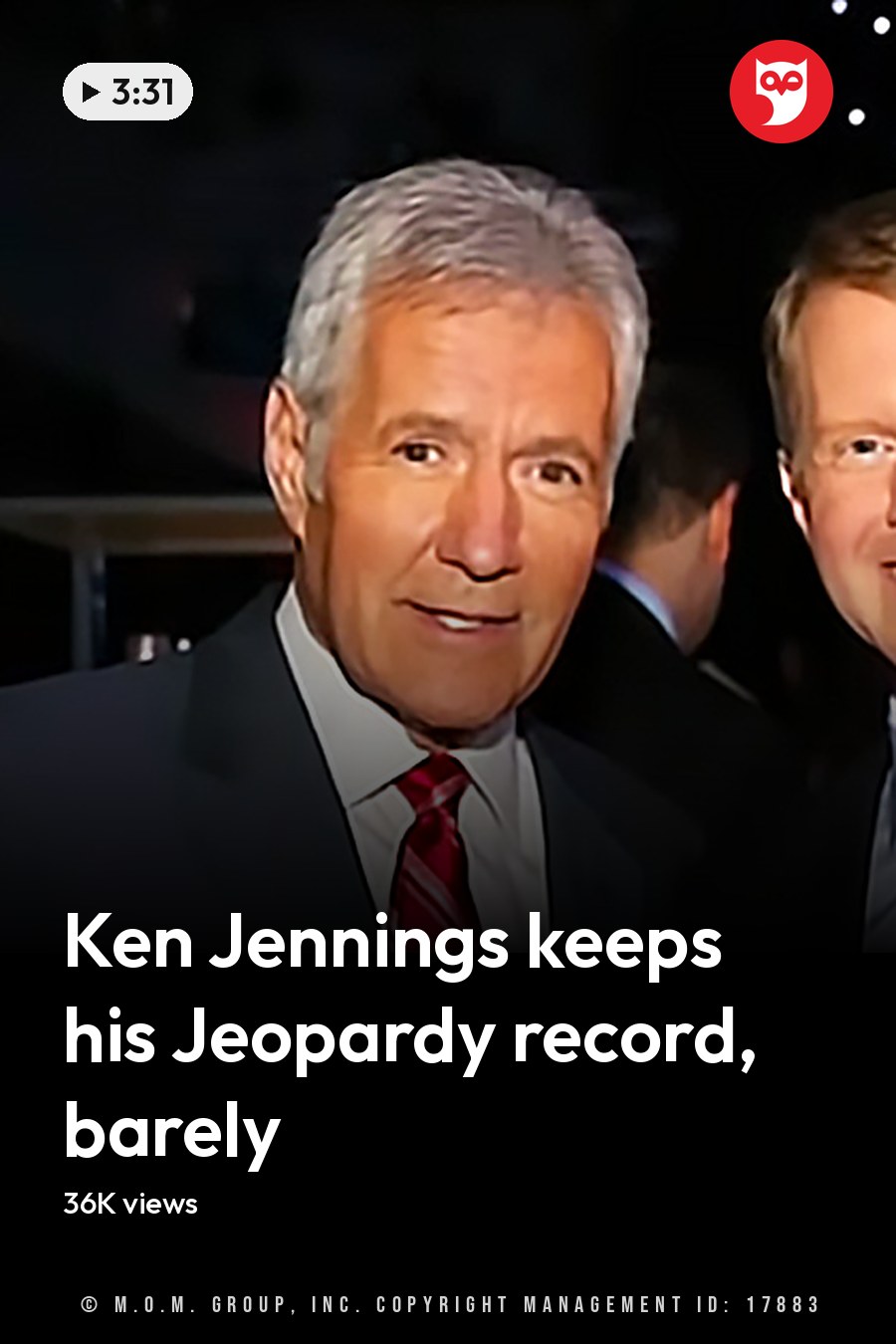 Two adult men in formal attire, one with gray hair and a red striped tie, another with brown hair and a patterned tie, standing indoors at an evening event space. The headline runs in white letters across the lower third.