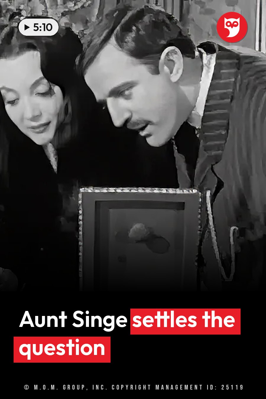 Two people lean over a framed object indoors, looking down closely at what is inside it. A headline runs in white letters across the lower third.