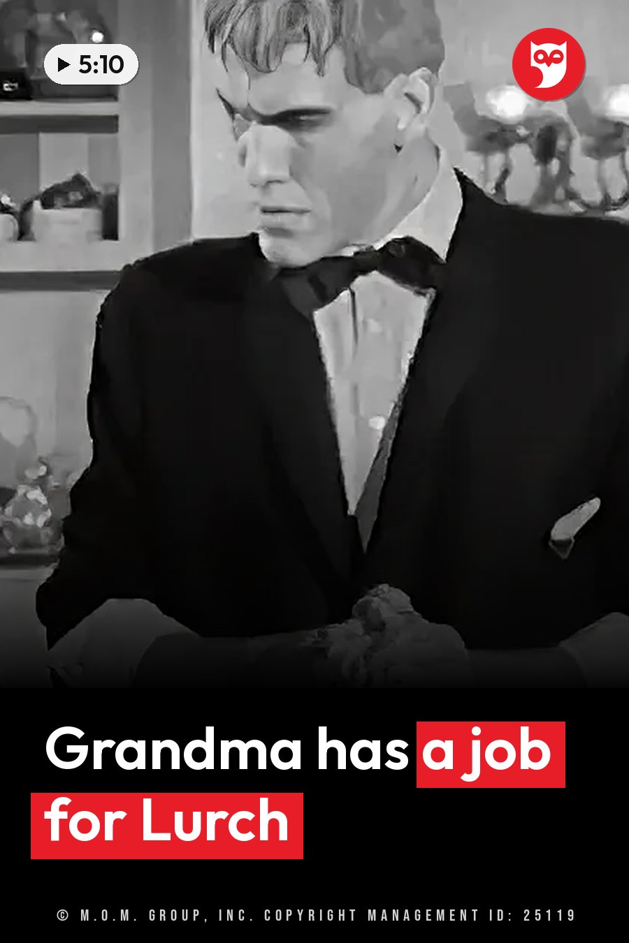 A man in a tuxedo and bow tie looks down at something on the table in front of him. A headline runs in white letters across the lower third.