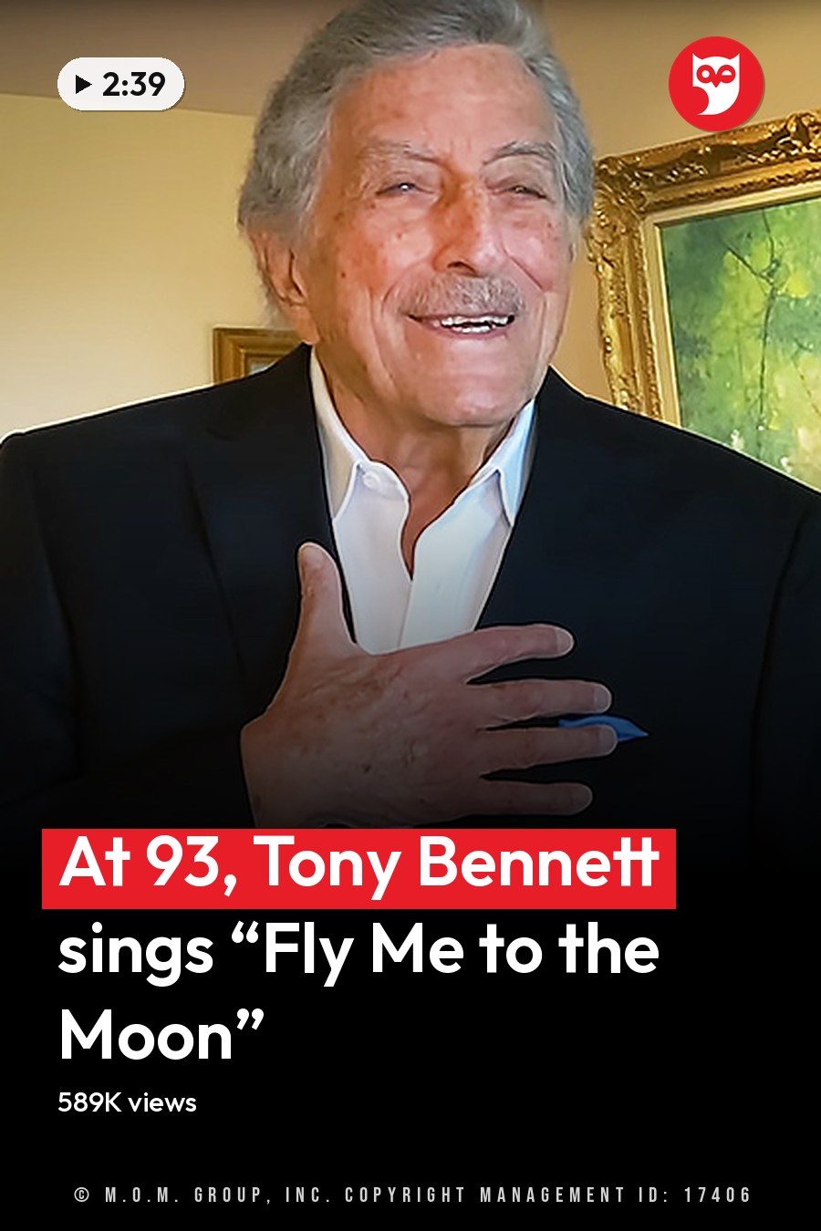 An older adult male wearing a black suit jacket with white shirt, standing indoors near a piano and framed photographs. The setting suggests a home office or living room with diffused natural light. The headline runs in white letters across the lower third.