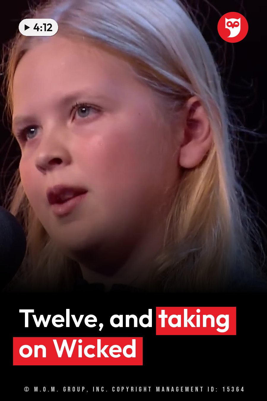 A young girl with blonde hair sings into a microphone on a stage under bright lights. A headline runs in white letters across the lower third.