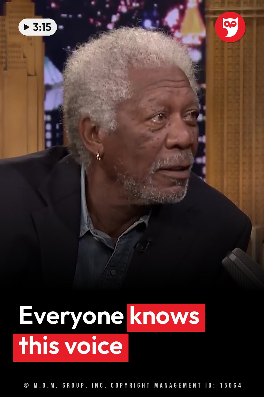 An older man with white hair speaks into a microphone during a talk show interview. A headline runs in white letters across the lower third.