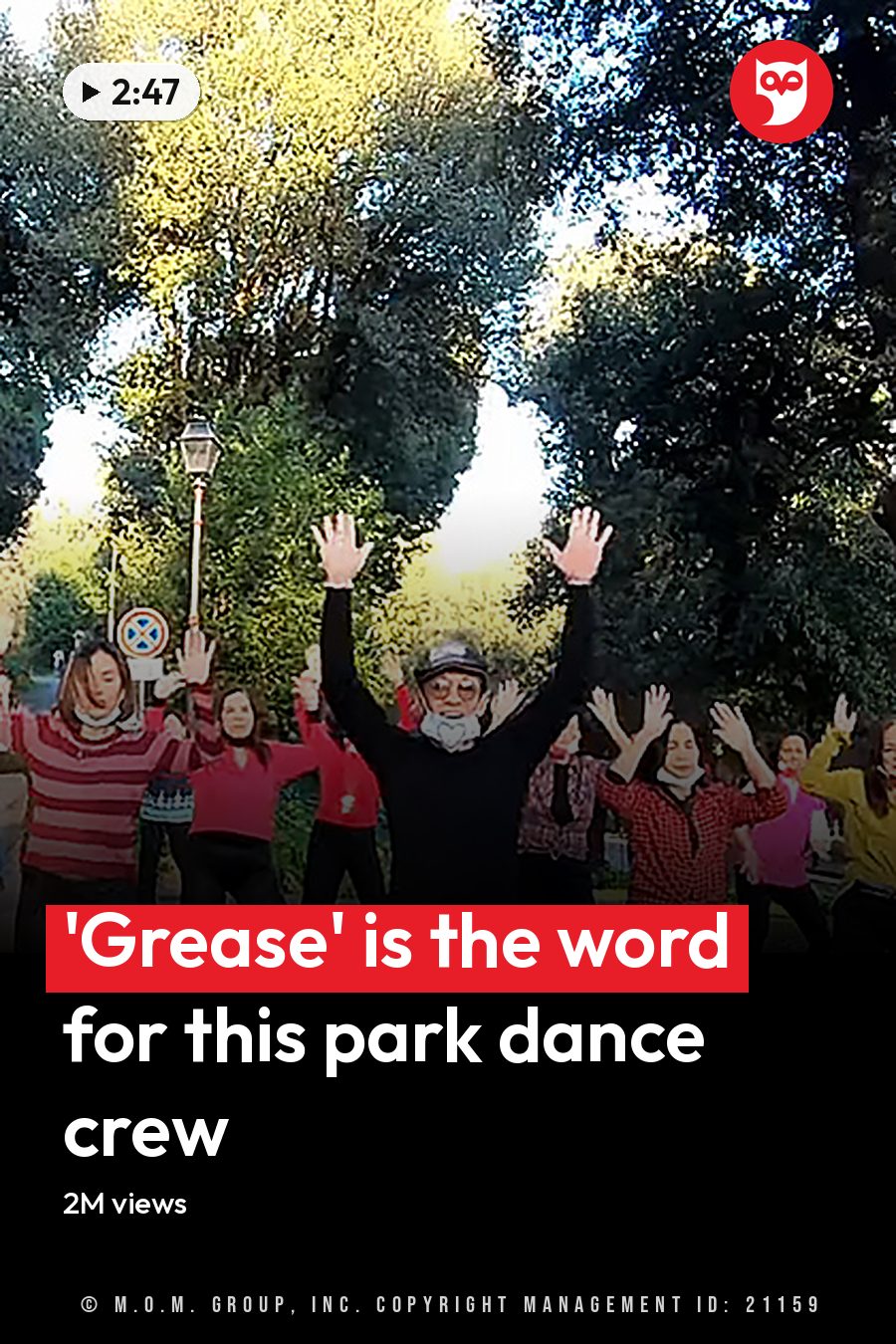 A group exercise class outdoors in a park-like setting with trees, paved path, and road signs indicating no entry; spring or summer foliage suggests daytime sunlight. The headline runs in white letters across the lower third.