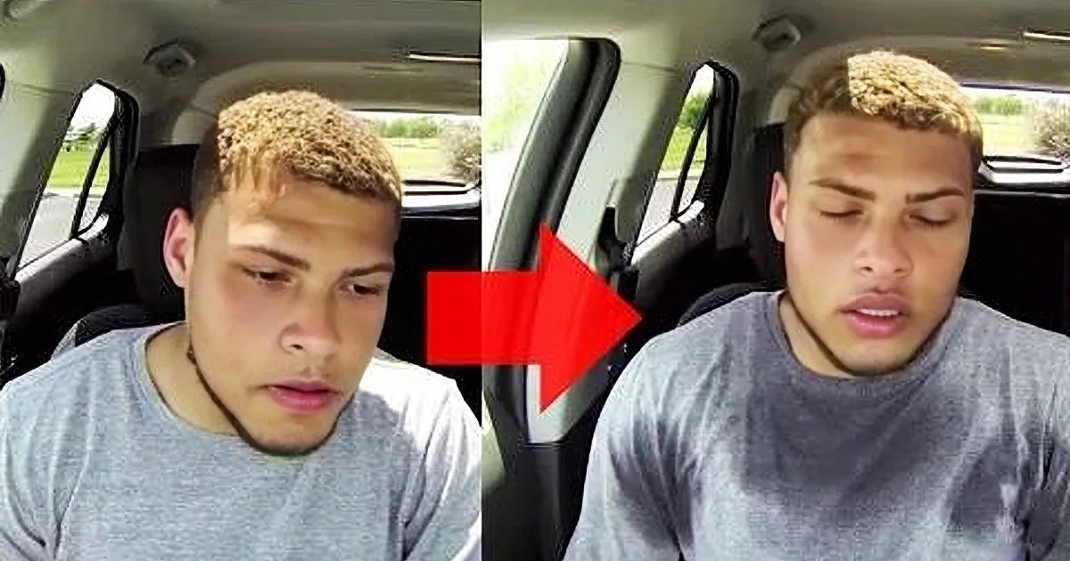 A young adult male in a car, wearing a gray t-shirt with cotton or cotton blend fabric, surrounded by an open area with grass and trees, suggesting spring or summer.