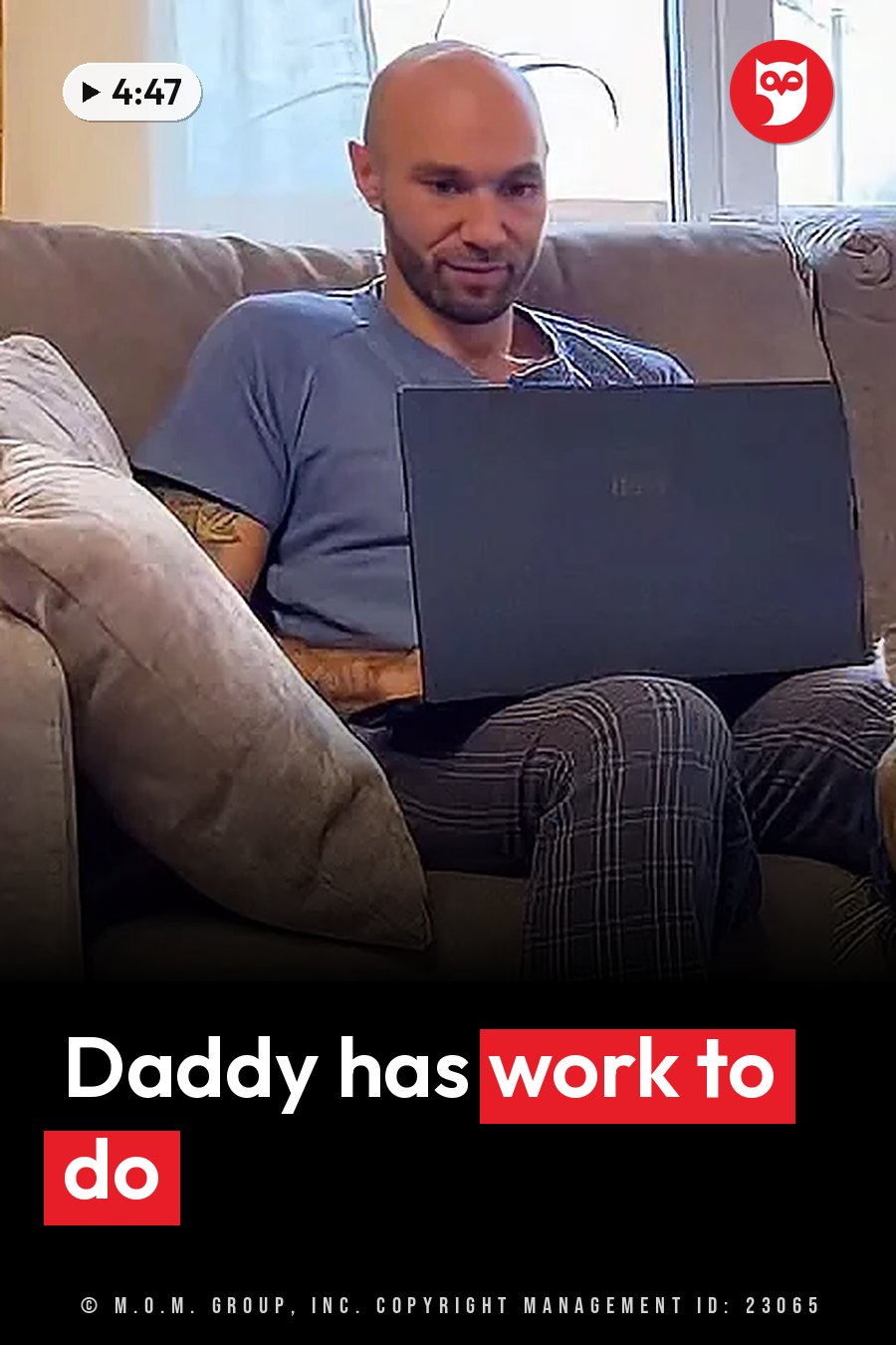 A bald man with a beard sits on a couch holding a laptop computer. A headline runs in white letters across the lower third.
