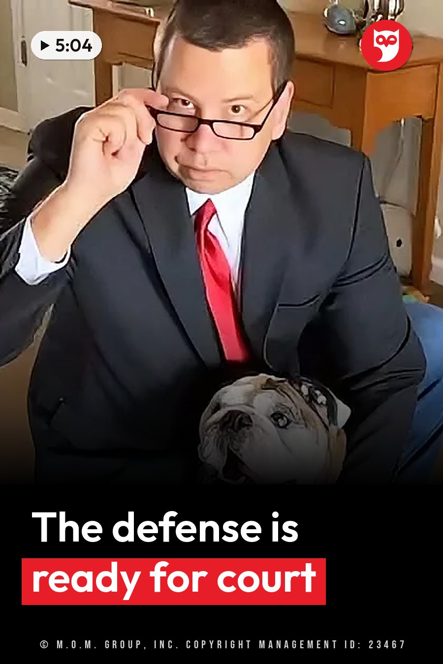 A man in a suit and red tie adjusts his glasses while holding a bulldog on his lap. A headline runs in white letters across the lower third.