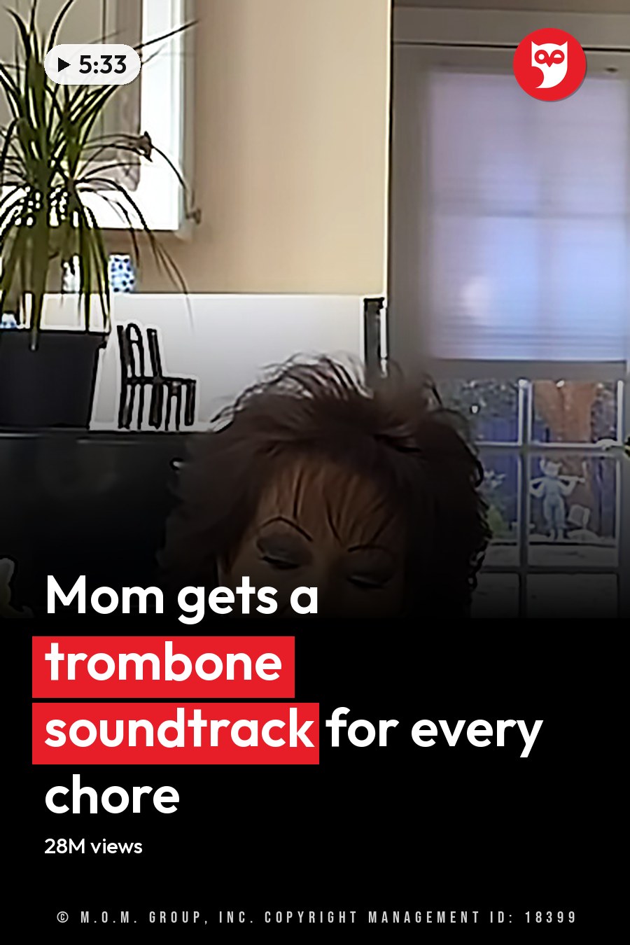 A middle-aged female in a dark blue lace-top with large hoop earrings stands indoors near a kitchen setting. A young adult male plays a gold trombone beside her, wearing camouflage pants and a gray t-shirt. The background includes white cabinets, tiled backsplash, black entertainment center, and a glass door leading outside. The headline runs in white letters across the lower third.