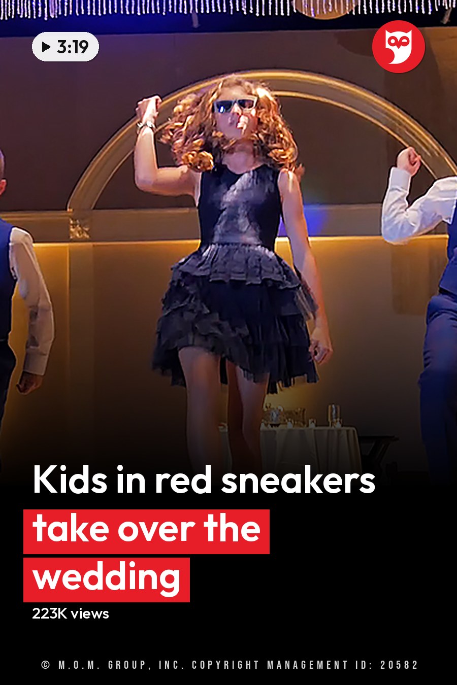 Children participating in a dance performance in an indoor event space with tables, chairs, and arched doorways at evening time. The headline runs in white letters across the lower third.