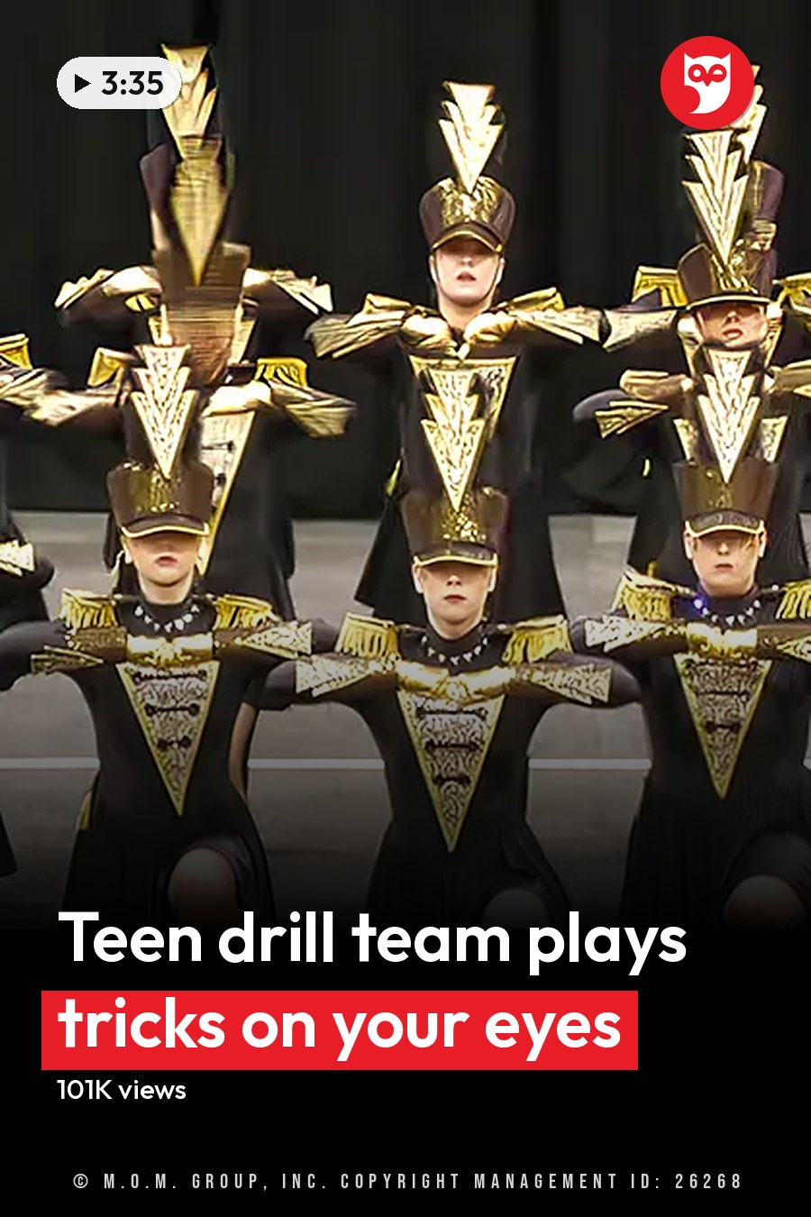 A group performance by young adult female dancers in a dance or marching band setting, wearing form-fitting uniforms with black and gold accents on stage under artificial lighting. The headline runs in white letters across the lower third.
