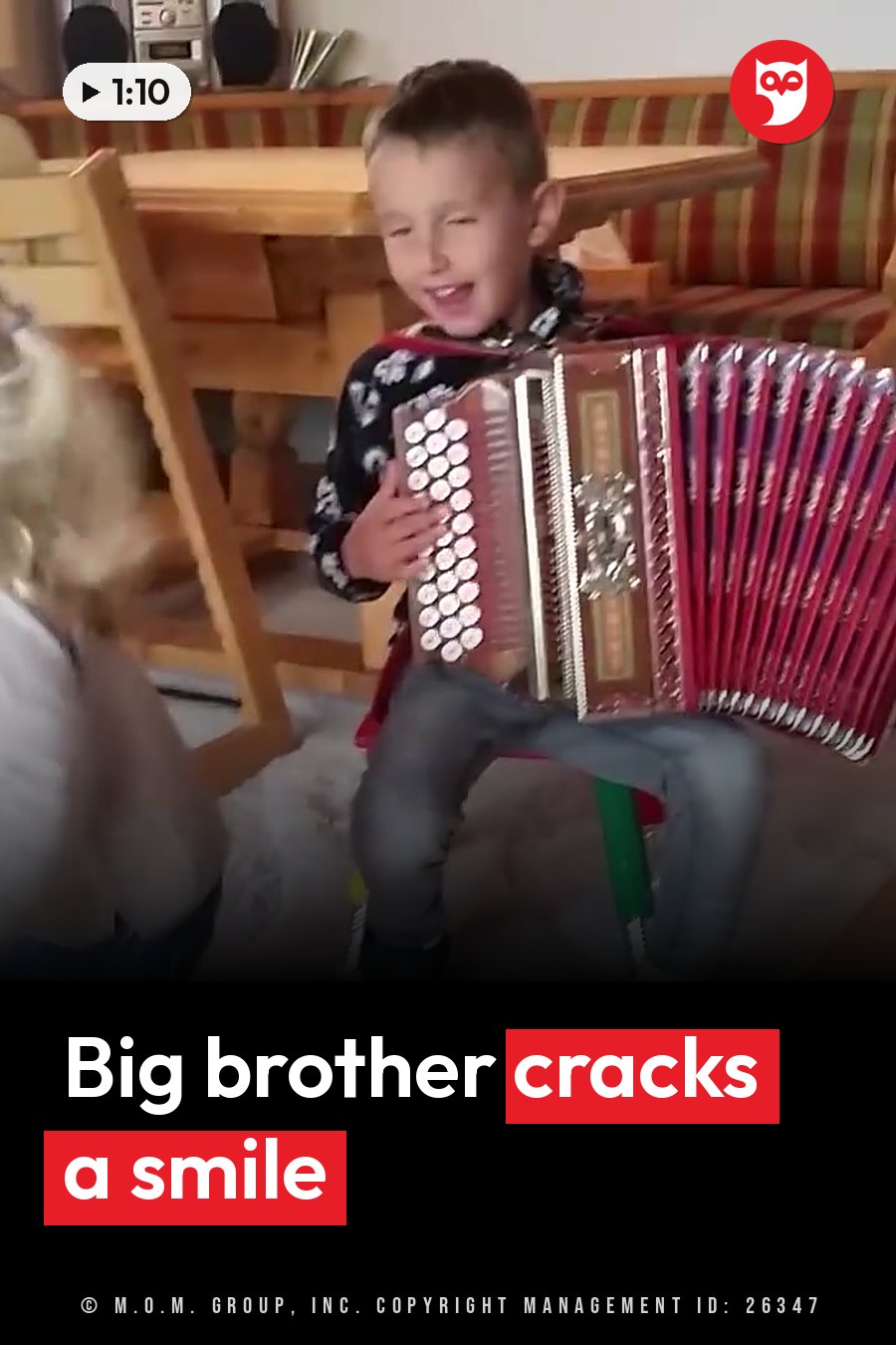 A young boy smiles while playing a red accordion, with another child partly visible beside him. A headline runs in white letters across the lower third.