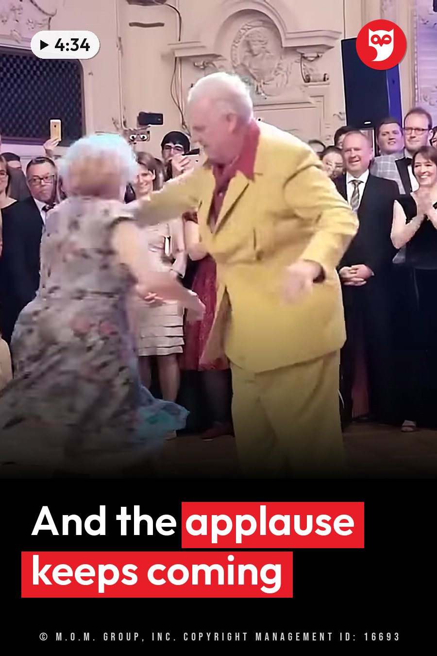 An elderly couple dances on a wooden floor as people around them watch and applaud. A headline runs in white letters across the lower third.