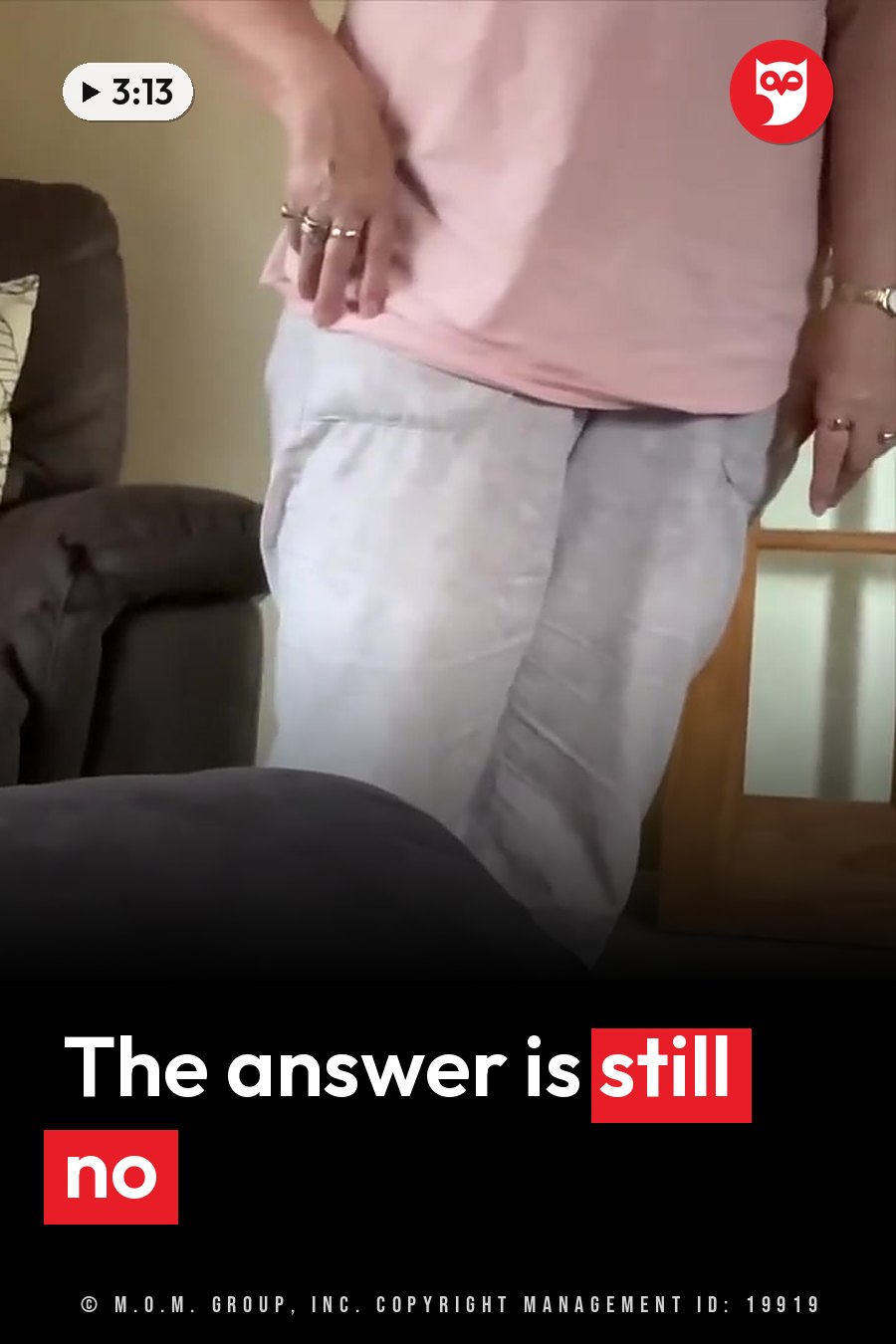 A person in a pink shirt and light pants stands indoors with a hand on one hip, near a chair and a wooden door frame. A headline runs in white letters across the lower third.